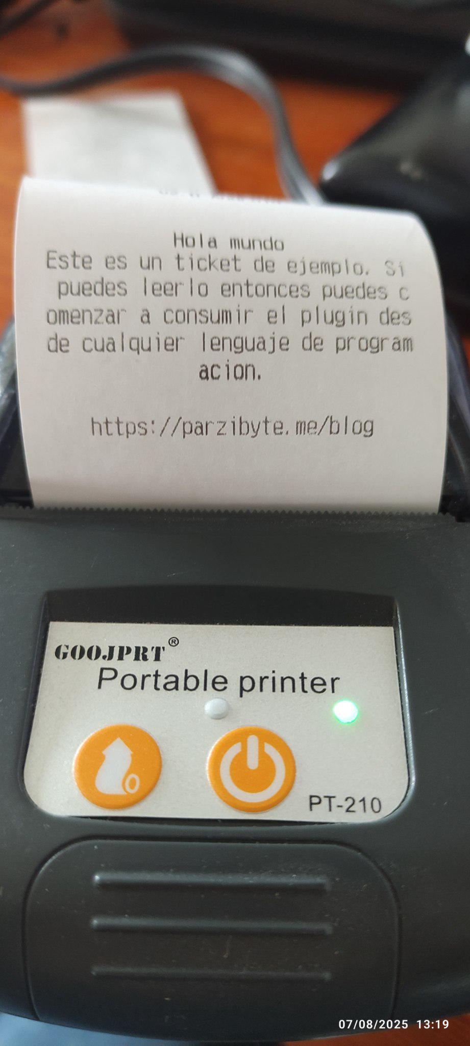 Impresora térmica Bluetooth con un ticket impreso. El ticket contiene el texto indicando que es un ticket de ejemplo y que si se puede leer entonces ya puede comenzar a consumir el plugin desde cualquier lenguaje de programación