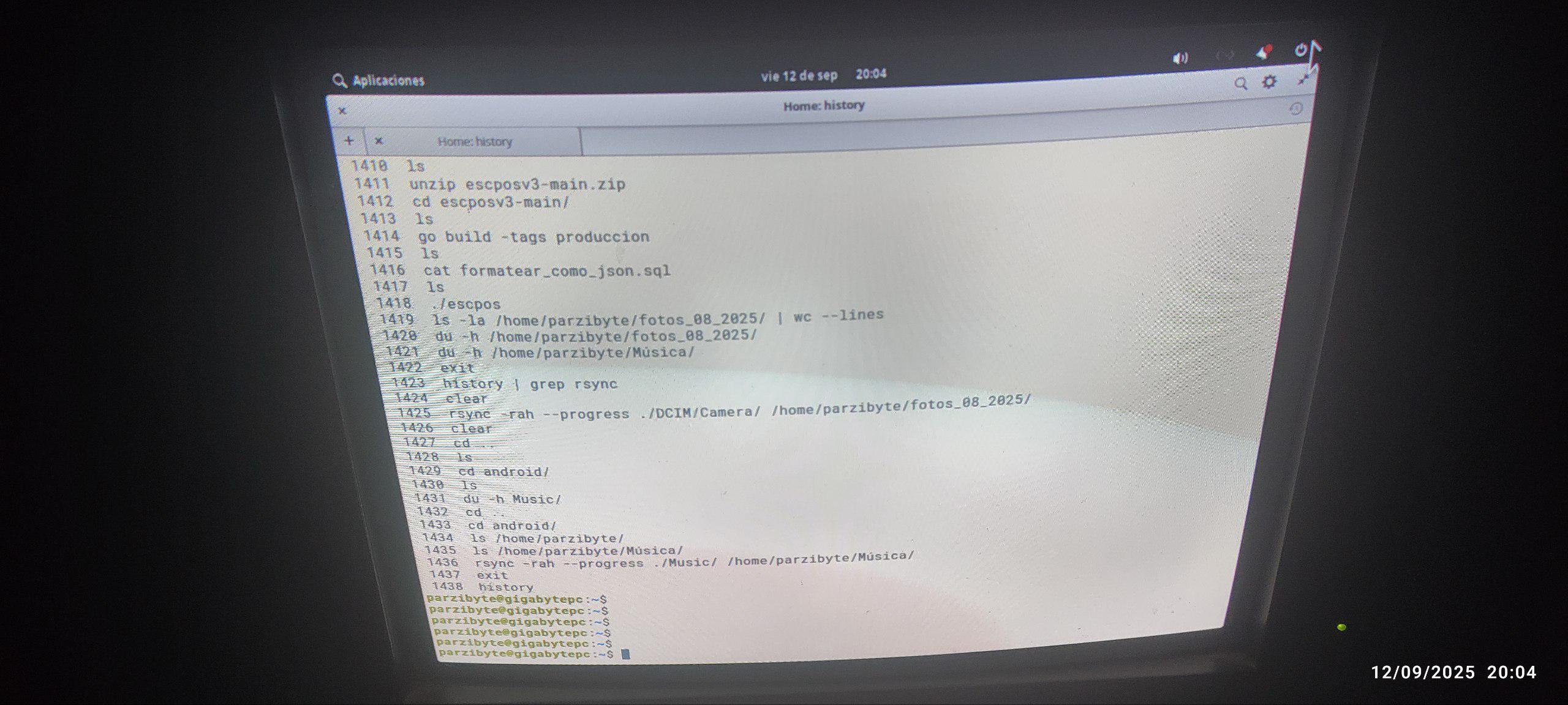 Monitor CRT conectado a una computadora con una terminal Linux. Se aprecia el historial de comandos entre los que se encuentra el de rsync usado para copiar varios archivos de manera segura y con reanudación